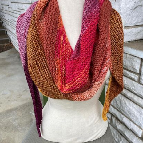 Boomerang Shawl hand knit with mixed fibers in oranges, yellows, reds and rose